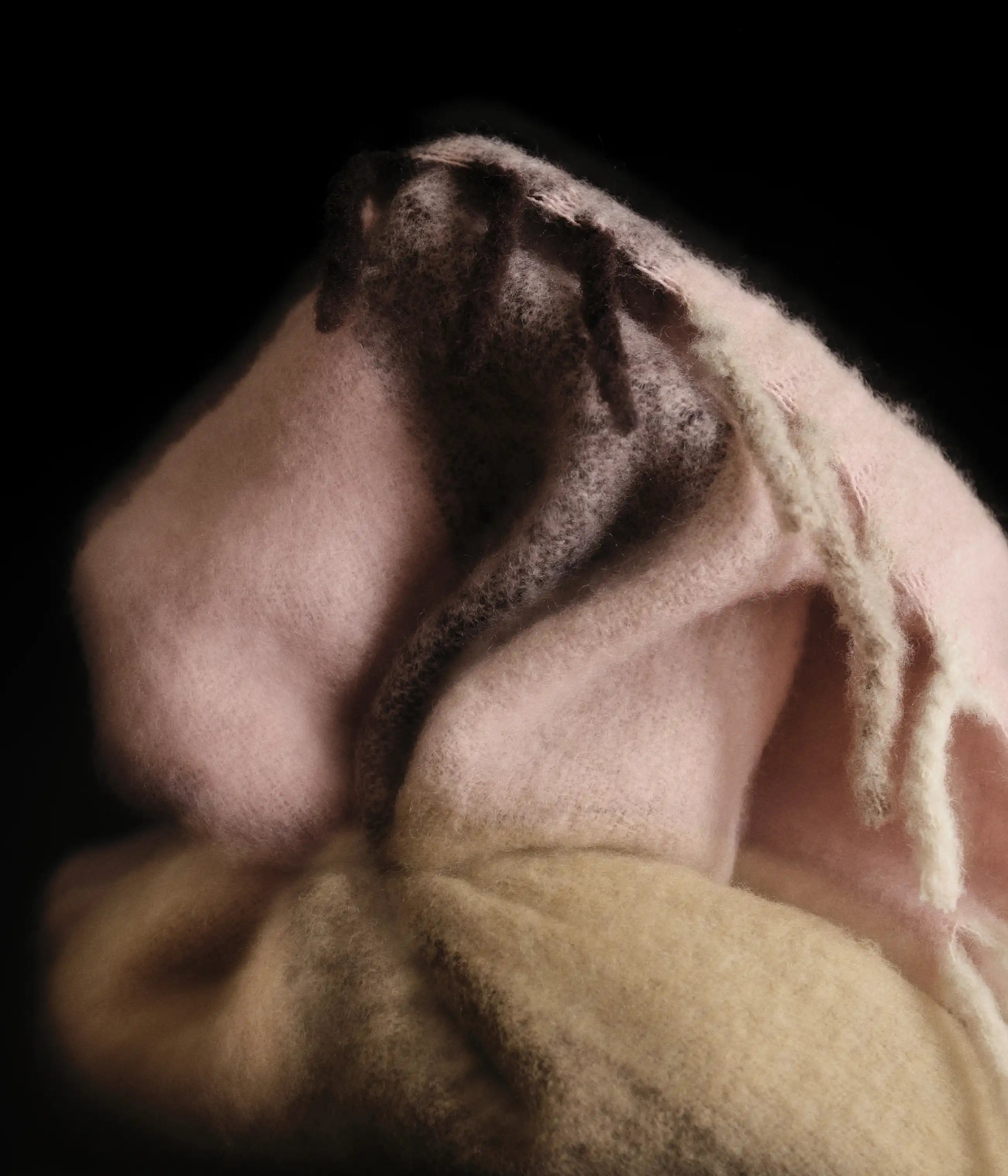 Nærbillede af et blødt børstet plaid i pink og gul med frynsekant